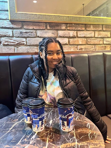 Picture of a woman sat in front of three Caffè Nero cups