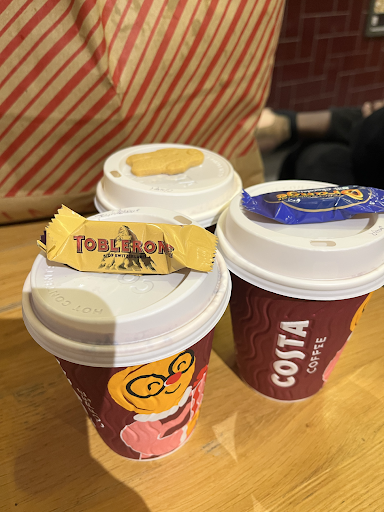 Picture of three costa coffee cups with chocolate treats on the lids