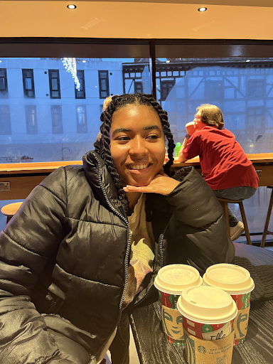 Picture of a woman sat in front of 3 coffee cups